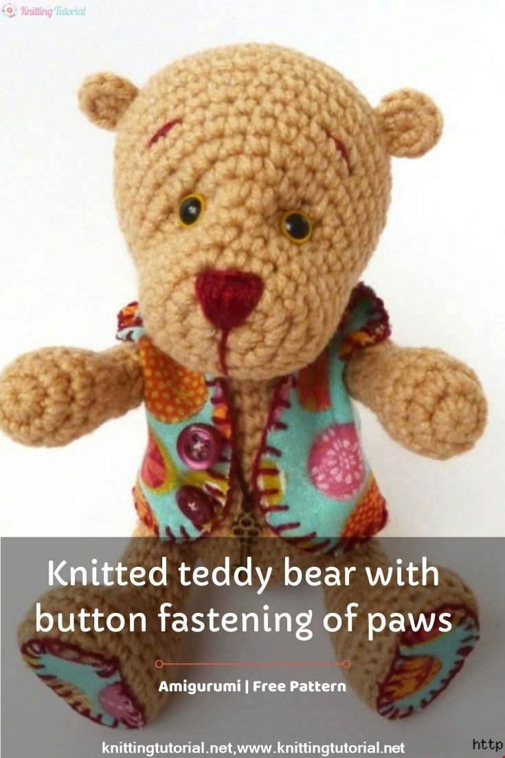 Knitted teddy bear with button fastening of paws
